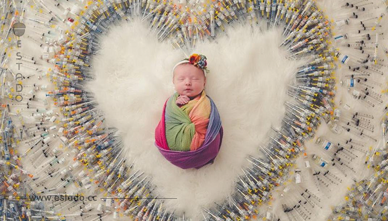 Un bebé es fotografiado con las jeringuillas que fueron necesarias en su parto