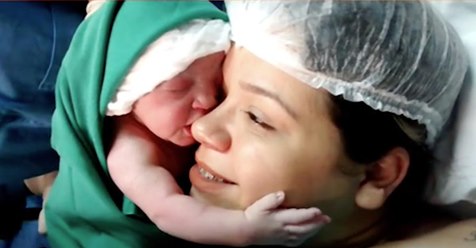 Bebé recién nacida se sujeta fuertemente a la carita de la madre