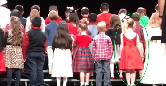 Coro navideño se prepara para actuar, pero una niña vestida de rojo se roba el espectáculo con su actitud