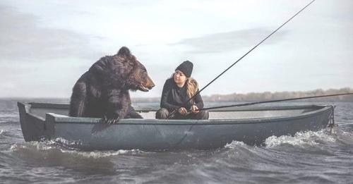 Graban a un oso pardo adoptado por una mujer mientras disfrutan un relajante día de pesca
